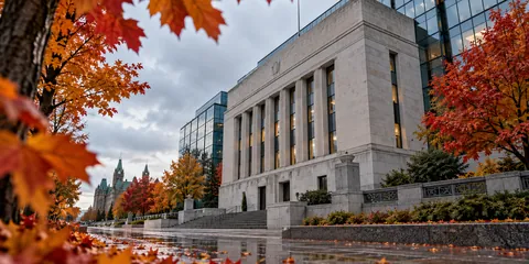 Institutional stone-and-glass building framed by autumn maple leaves on a wet Ottawa sidewalk